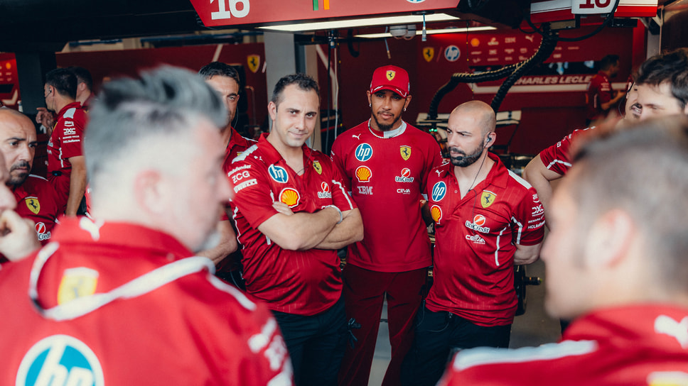 Брифинг с участием гонщиков в боксах Ferrari, в центре — Льюис Хэмилтон
