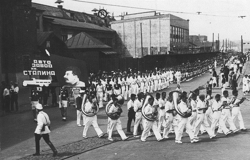 Колонна Завода имени Сталина на параде физкультурников, 1934 год. Слева — заводоуправление, правее — новые цеха, возведенные после реконструкции, когда завод начал расти в сторону Москва-реки. Автозаводская улица тогда называлась Амовский проезд или Амовская улица