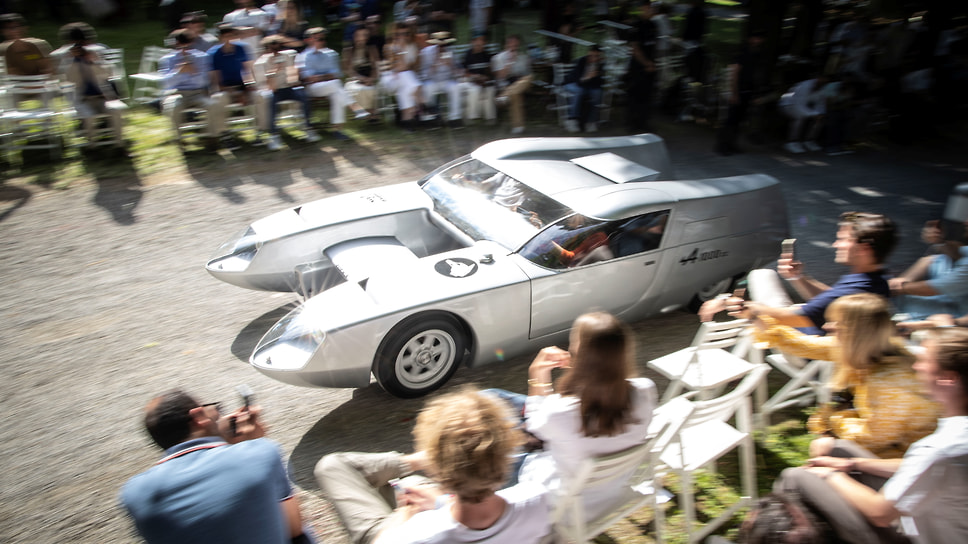 Один из шоустопперов Concorso d’Eleganza Villa d’Este 2025 стал OSI Silver Fox Prototype. Произвел он сенсацию и на Туринском автосалоне в 1967 году, где был представлен новаторским итальянским кузовным ателье Officine Stampaggi Industriali. Silver Fox был радикальным концепт-каром, который больше напоминал катамаран, чем автомобиль. Идея машины с двумя кузовами возникла у гонщика Пьеро Таруффи, которого прозвали Silver Fox из-за седых волос и хитрого стиля вождения. Таруффи, к слову, был последним победителем легендарной гонки Mille Miglia в 1957 году.
