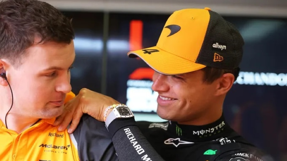Ландо Норрис (справа) общается с сотрудником команды McLaren