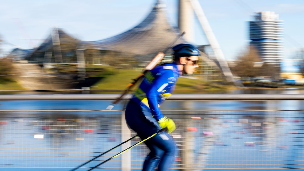 «Стреляющий лыжник» движется на фоне комплекса BMW Welt в Мюнхене. Автомобильный концерн — давний партнер национальной команды Германии по биатлону