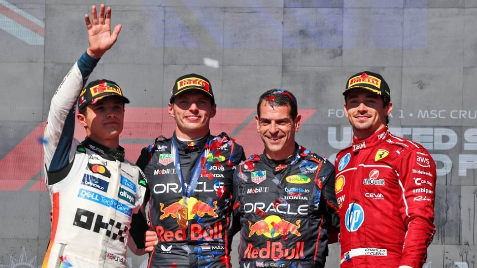 Подиум Гран-при США: Норрис, Ферстаппен, представитель конюшни Red Bull и Леклер (слева направо)